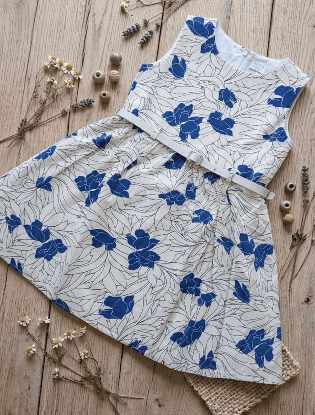 whisperingpoppers summer frocks Floral Cotton Frock with Belt — Vintage Style Girls 1y to 6 Years  blue and white colour floral printed desgin.flat lay detail of the frock  knee length  with silver belt .front view of the frock.perfect for hot summer days in pakistan.wear it on all day long  gatherings.event lunch and dinner.breathable comfortable fabric.imported