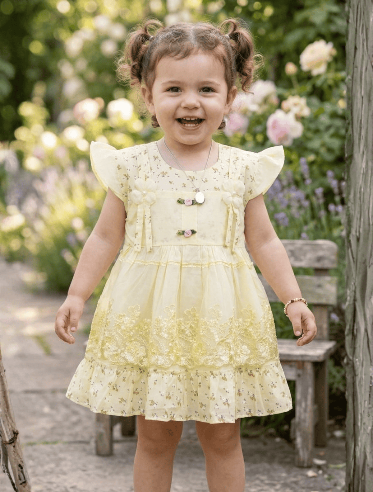whisperingpoppers summer frocks Butter Yellow Floral Lawn Frock with Lace Embroidery — Girls 9month-1.5 Years .girl showing front side of the frock.breathable lawn printed fabric.perfect for summer season in pakistan.flower motive and embroidered net details give this frock beautiful elegance .round neckline.pretty in yellow frock