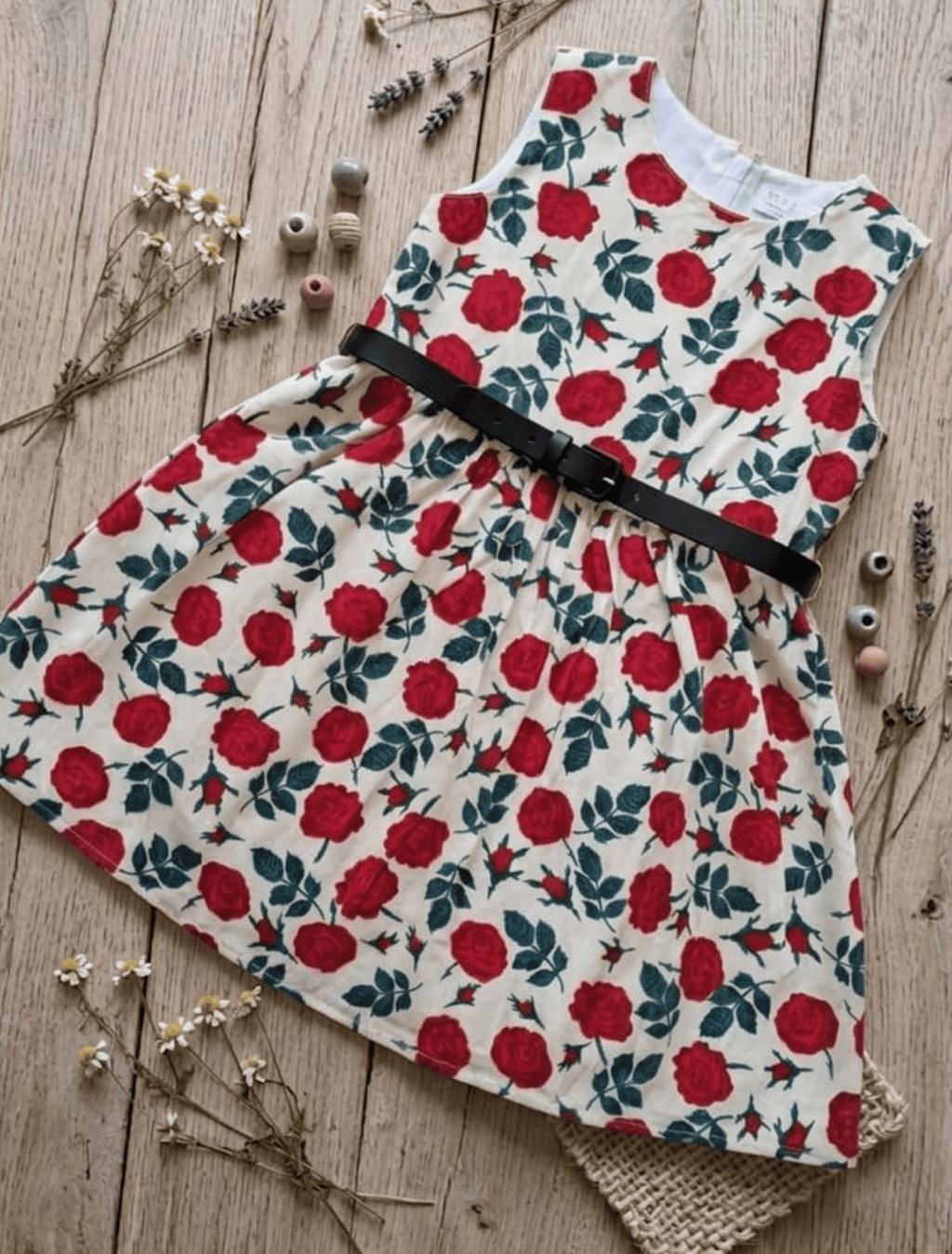 whisperingpoppers summer frocks Floral Cotton Frock with Belt — Vintage Style Girls 1y to 6 Years  red and teal green floral pattren on cotton vintage style frock with black leather belt .flat lay detail of thhe frock.. knee length vintage cotton frock .showing front view of the frock .perfect in pakistan summer season.sleevlee frock
