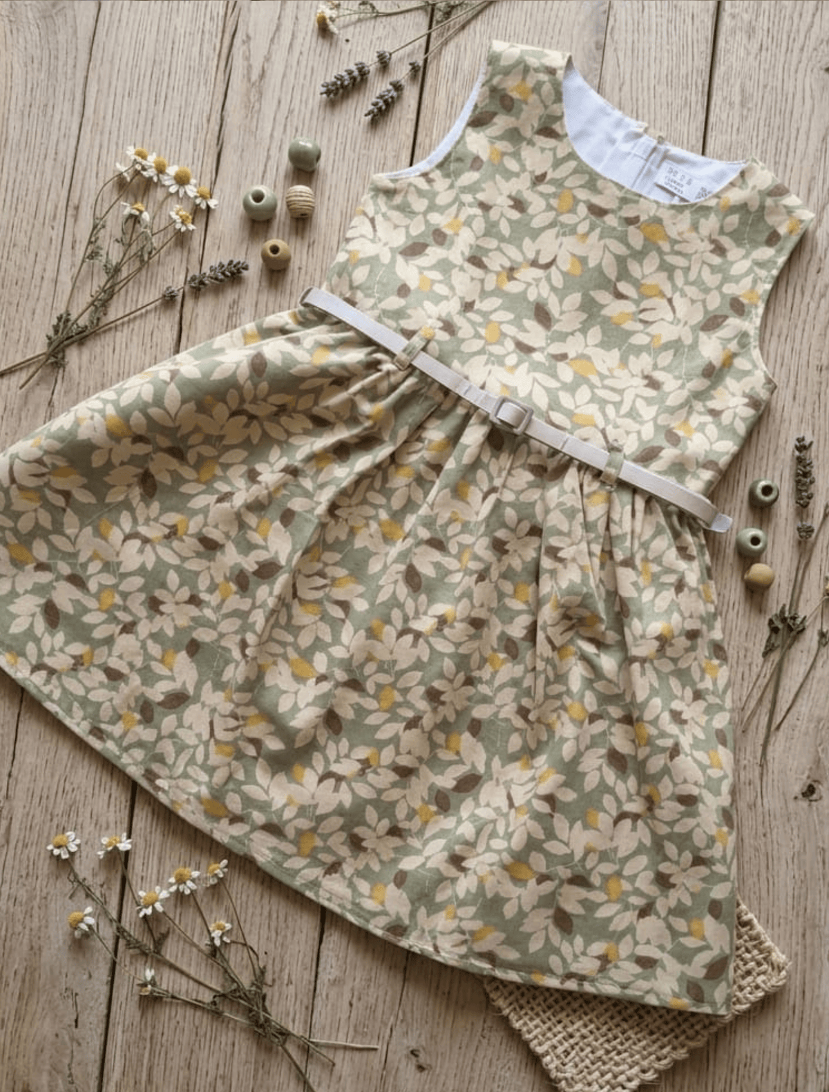 whisperingpoppers summer frocks Floral Cotton Frock with Belt — Vintage Style Girls 1y to 6 Years sage green colour floral printed desgin.flat lay details. knee length  with silver belt .front view of the frock.perfect for hot summer days in pakistan.wear it on all day long  gatherings.event lunch and dinner.breathable comfortable fabric.imported